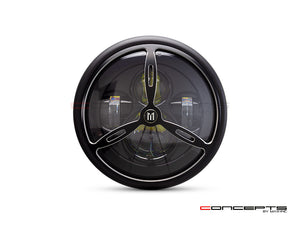 This is a photo of a motorcycle headlight, featuring a round, black casing, gold accent trim, and a bright bulb at the core, presenting a refined and durable design